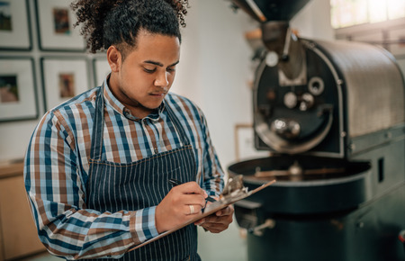 Business owner of a coffee roastery checking a quality control listの写真素材