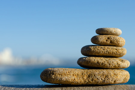 A stone cairn constructed from beach pebbles with the city of Durban, South Africa, in the backgraound.の写真素材