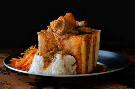 A Durban Bunny Chow - or, in this case, a quarter mutton bunny - served with sambals.の写真素材