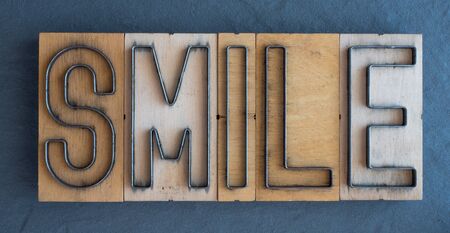 Old wood and steel number plate dies spell out the word SMILEの写真素材