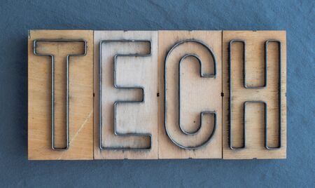 Old wood and steel number plate dies spell out the word TECHの写真素材