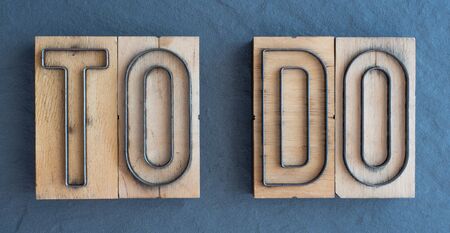 Old wood and steel number plate dies spell out the words TO DOの写真素材