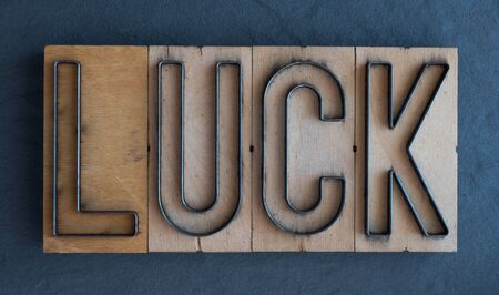 Old wood and steel number plate dies spell out the word LUCKの写真素材