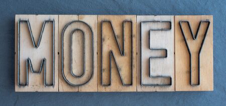 Old wood and steel number plate dies spell out the word MONEYの写真素材