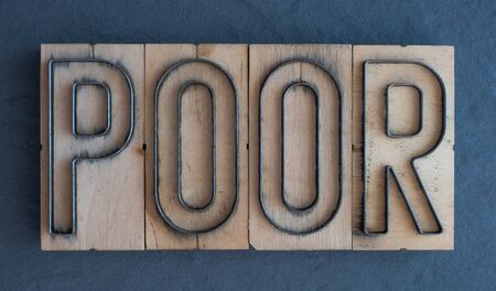 Old wood and steel number plate dies spell out the word POORの写真素材