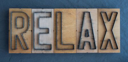 Old wood and steel number plate dies spell out the word RELAXの写真素材