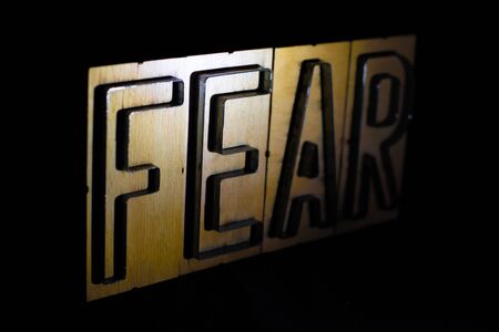 Old wood and steel number plate dies spell out the word FEARの写真素材