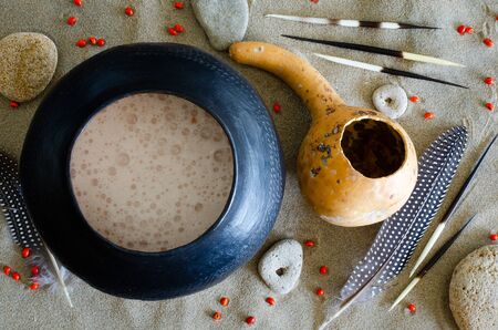 African beer, referred to as "utshwala" in Zulu, is brewed from mealie meal and drunk out of a clay drinking vessel called an "ukhamba". A hollowed out calabash is used to scoop beer into the "ukhamba".の写真素材