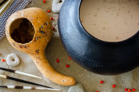 African beer, referred to as "utshwala" in Zulu, is brewed from mealie meal and drunk out of a clay drinking vessel called an "ukhamba". A hollowed out calabash is used to scoop beer into the "ukhamba".の写真素材
