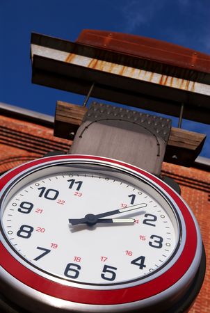 A large clock hanging from a post.