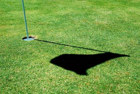 A golf hole on a green of a golfcourse with focus on the flag.の写真素材