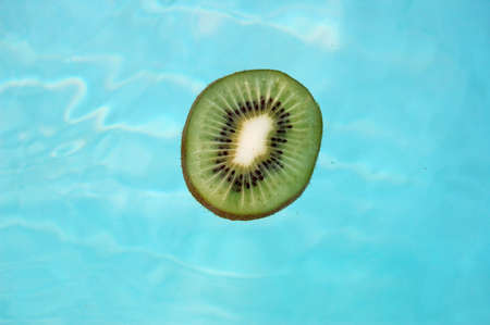 a slice of kiwi floating on the swimming poolの写真素材
