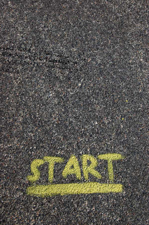 A yellow start painted on black pavementの写真素材