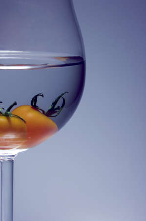 Close up of tomato inside the wine glass. soft lightning is grey+blue backgroundの写真素材