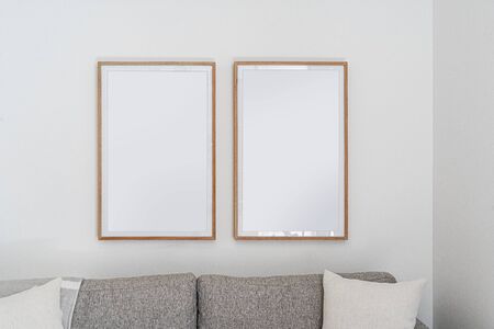 Interior decoration, empty wooden vertical frames, poster white canvas mock up on a white wall, living room template from viewの写真素材