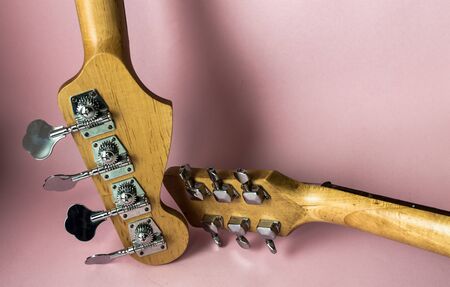Closeup of Bass and guitar heads in pink background