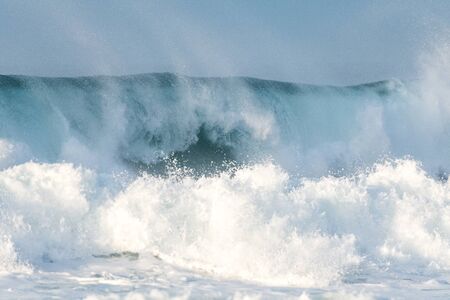 Surfer swallowed by a big wave on a beach on the north coast of Spain