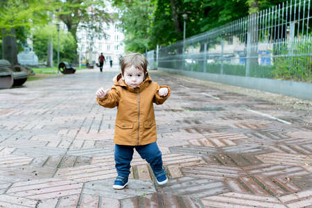 A year and a half old baby taking his first steps in the parkの写真素材
