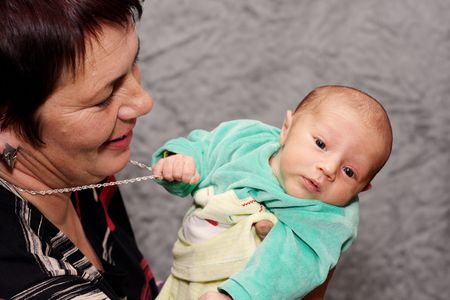 baby trying to steal necklace from grandmother