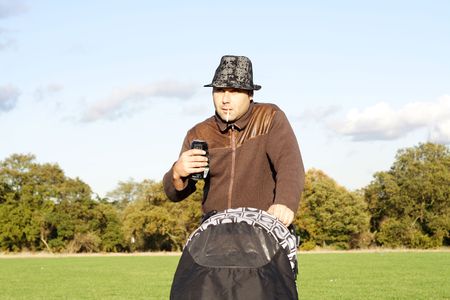 Careless father drinking and smoking while pushing pushchairの写真素材