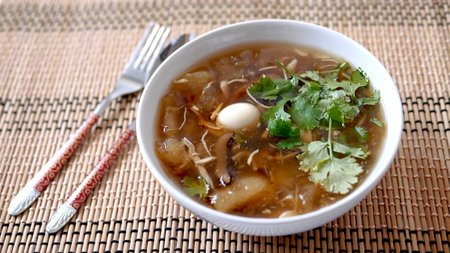 Braised  fish maw soup with chicken meat, quail egg and mushroom in deep bowlの写真素材