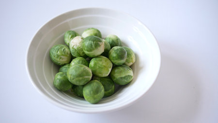 Heap of Brussel Sprouts in bowl isolated on white backgroundの写真素材