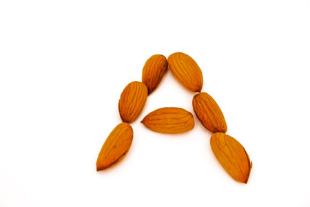Almond nuts forming A letter isolated on white backgroundの写真素材