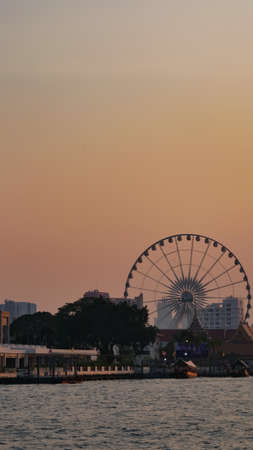 Landscape view of Farris Wheel at Chao Praya river in sunset, Bangkok, Thailandの写真素材
