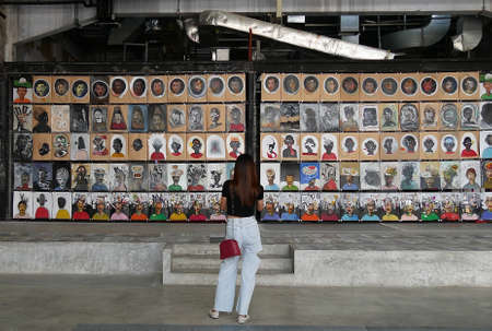January 7 2021 - Bangkok, Thailand : back view portrait of woman looking at paintings in art gallery exhibition, Long 1919, Bangkok, Thailandのeditorial素材