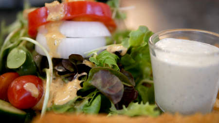 Green fresh salad and sour cream dressing on the side.の写真素材