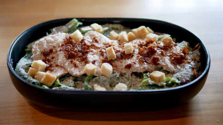 Fresh Cezar salad with romaine lettuce,  chicken, bacon and bread.の写真素材