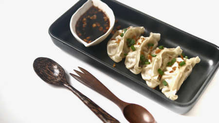 Steamed Gyoza or dumpling stuffed ground pork dipping with garlic soy sauce on white background.の写真素材