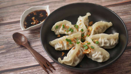 Steamed Gyoza or dumpling stuffed ground pork dipping with garlic soy sauceの写真素材