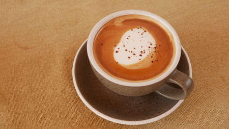 A cup of cappuccino on wood table.の写真素材