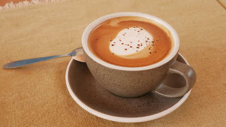 A cup of cappuccino on wood table.の写真素材