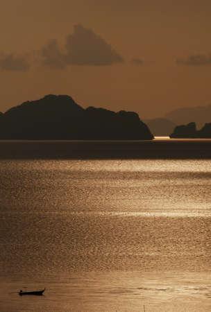 Dramatic sunset sky above the sea with silhouette mountain in foreground, beautiful seascape after sunset.の写真素材