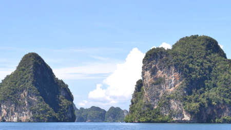 Exotic scenery islands with cloudscape and calm waters of Andaman sea in Krabi Province, Thailand, Selective focus on scene.の写真素材