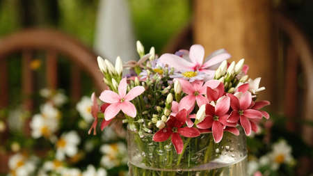 A bouquet of variety of flowers in a vase on the table, spring and summer background.の写真素材