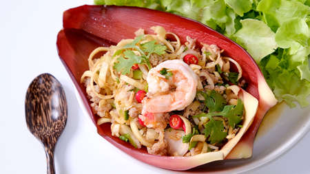Thai banana blossom spicy salad with shrimp and ground pork on banana blossom leaves on white background (Yum Hua Plee).の写真素材