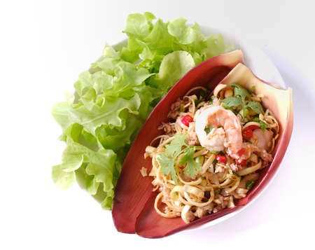 Thai banana blossom spicy salad with shrimp and ground pork on banana blossom leaves on white background (Yum Hua Plee).の写真素材