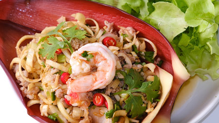Top view Thai banana blossom spicy salad with shrimp and ground pork on banana blossom leaves on black background (Yum Hua Plee).の写真素材