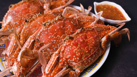 Steamed crabs with spicy sauce isolated on black background.の写真素材