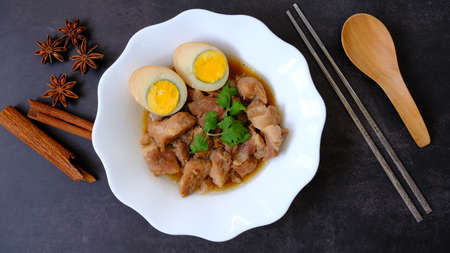 Top view egg and pork stew (braised) with dried anise and cinnamon on black background.の写真素材