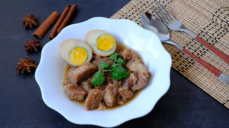Top view egg and pork stew (braised) with dried anise and cinnamon on black background.の写真素材