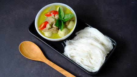 Top view green curry chicken and fish ball with rice noodle (vermicelli) on black  background.の写真素材