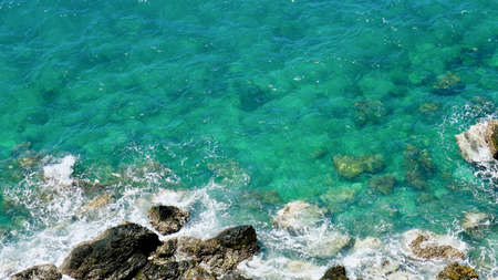 Aerial view of sea waves and rocky coast, Waves swim to the rocky shore with copy space.の写真素材