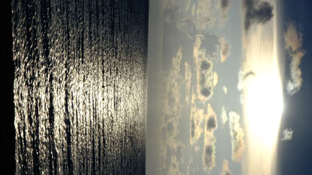 Sunbeams breaking through the sky in a seascape at sunset.の写真素材