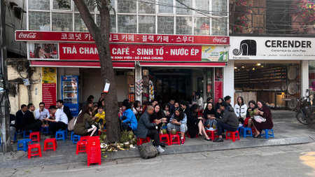 November 18 2022 - Hanoi, Vietnam : People sit on small plastic seat having coffee or tea on sidewalk, coffee stall
in Hanoi.のeditorial素材