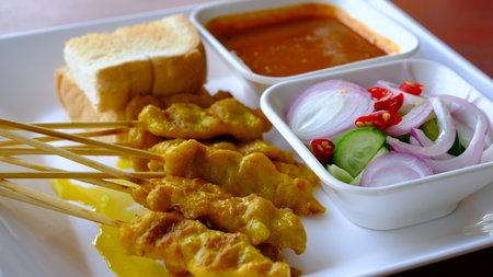 Grilled pork or satay pork served with peanut sauce, cucumber salad sweet  and grilled toast, Asian appetizer.の写真素材