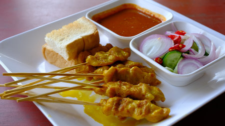 Grilled pork or satay pork served with peanut sauce, cucumber salad sweet  and grilled toast, Asian appetizer.の写真素材
